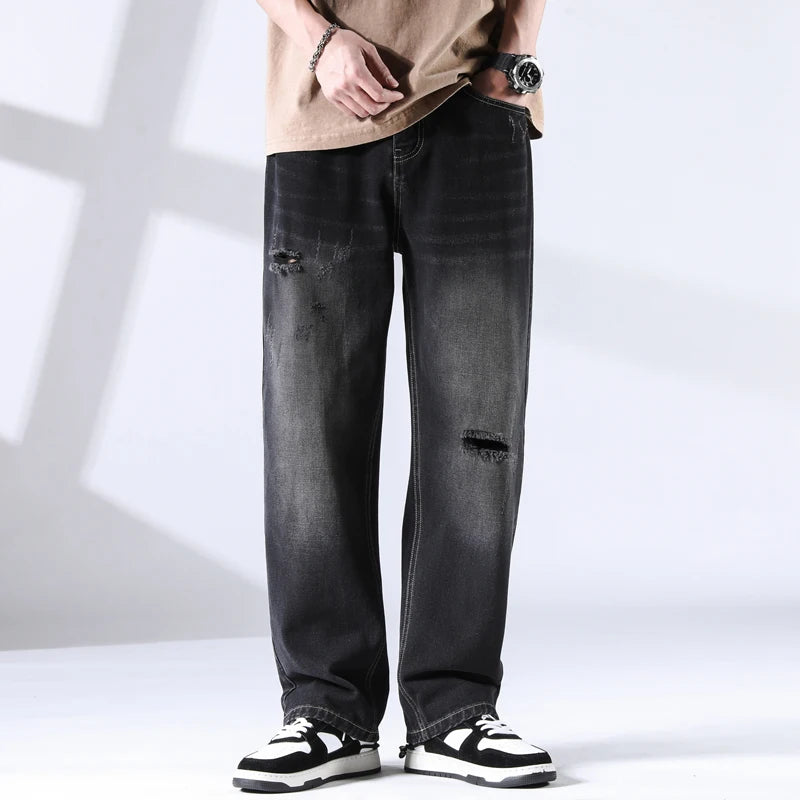 Black distressed straight leg jeans with fade wash and ripped knee, front view