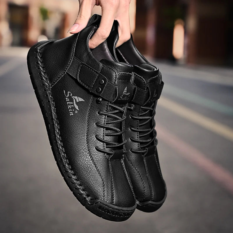 Black men's sneakers in textured leather with soft lining and elastic opening, handheld