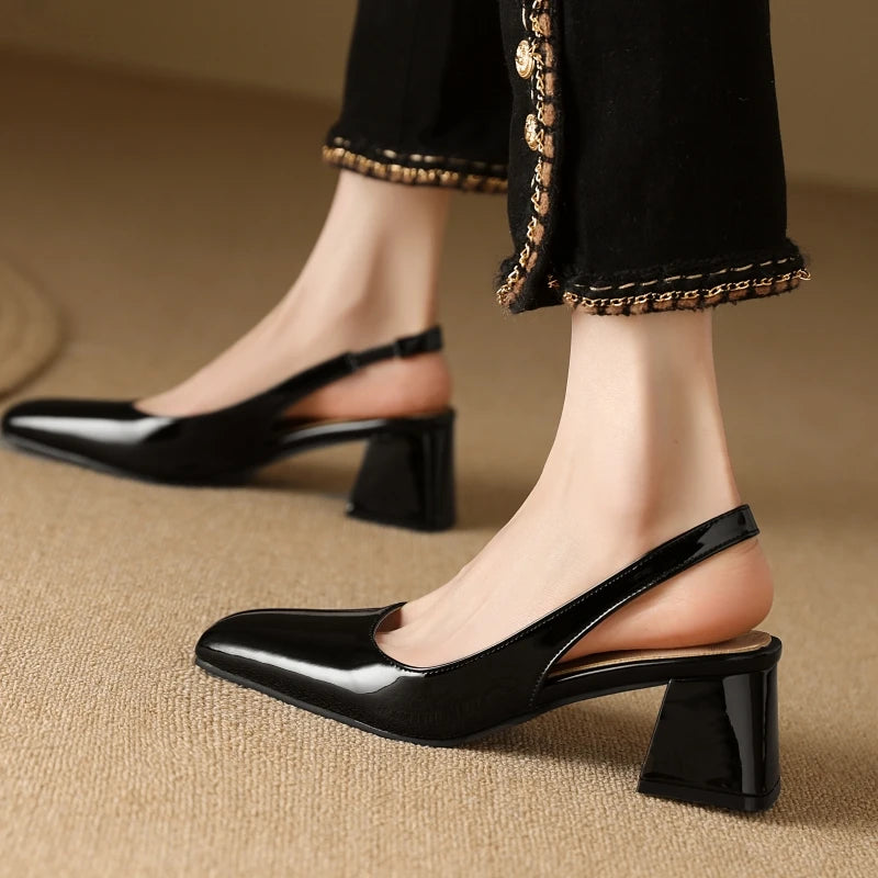 Black patent leather slingback pumps with medium heel, worn with skirt
