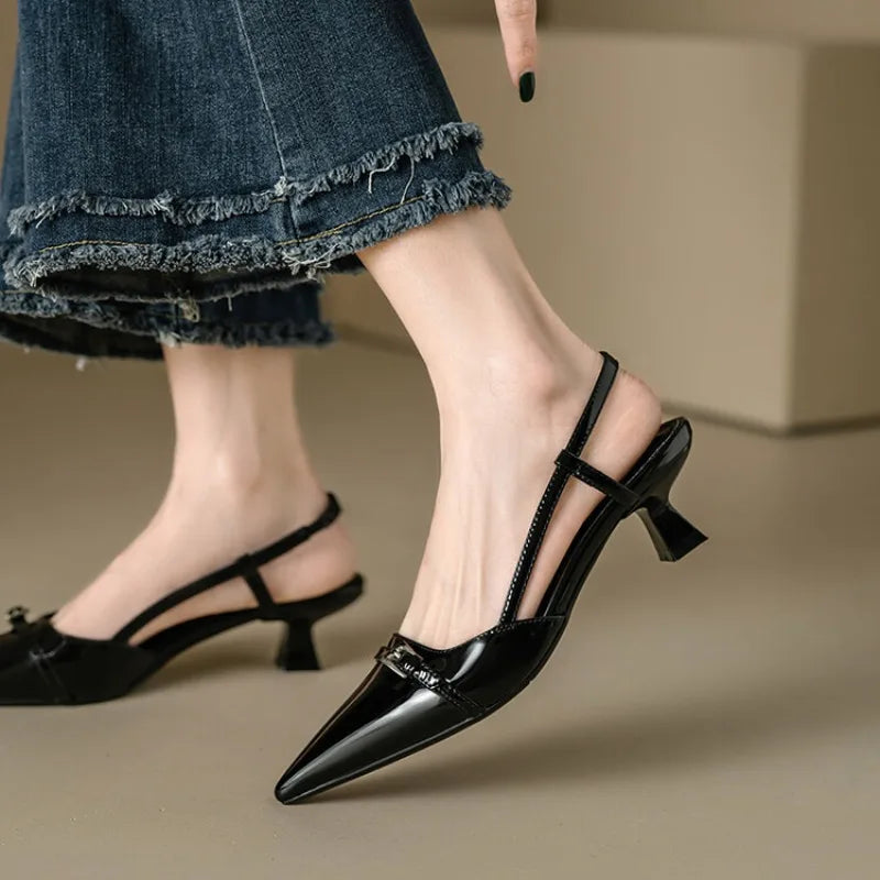 Black patent slingback heels worn with jeans, side view