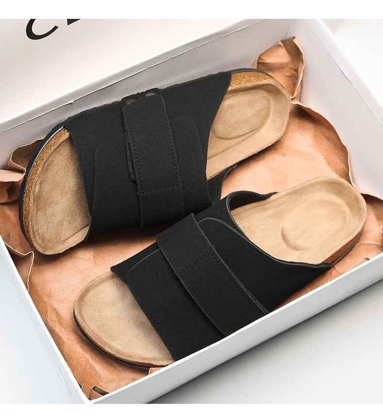 Black suede men's sandals with cushioned footbed in shoebox, top-down view