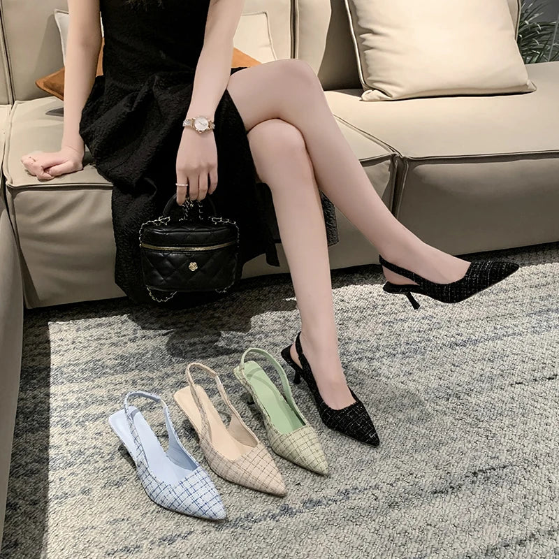 Black tweed slingback heels paired with black dress, side angle