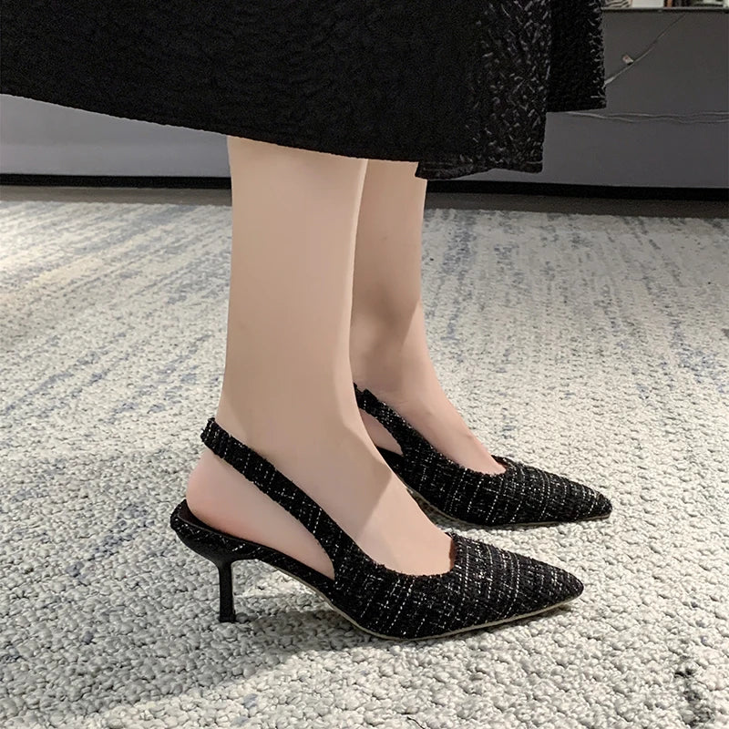Blue tweed slingback heels on model’s feet near lamp table
