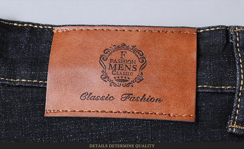 Branded leather patch on waistband of classic men’s jeans with decorative emblem