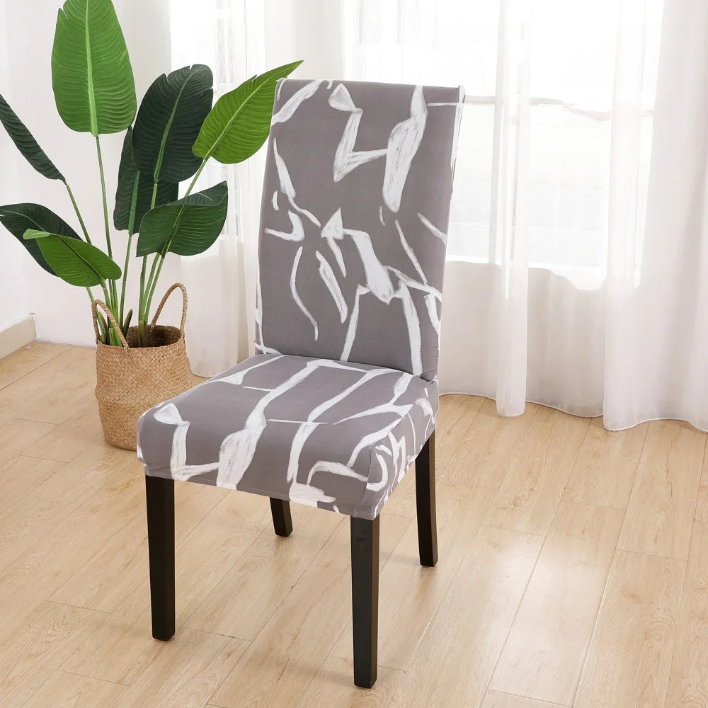 Brown Gray chair slipcover with white abstract brushstroke design beside houseplant