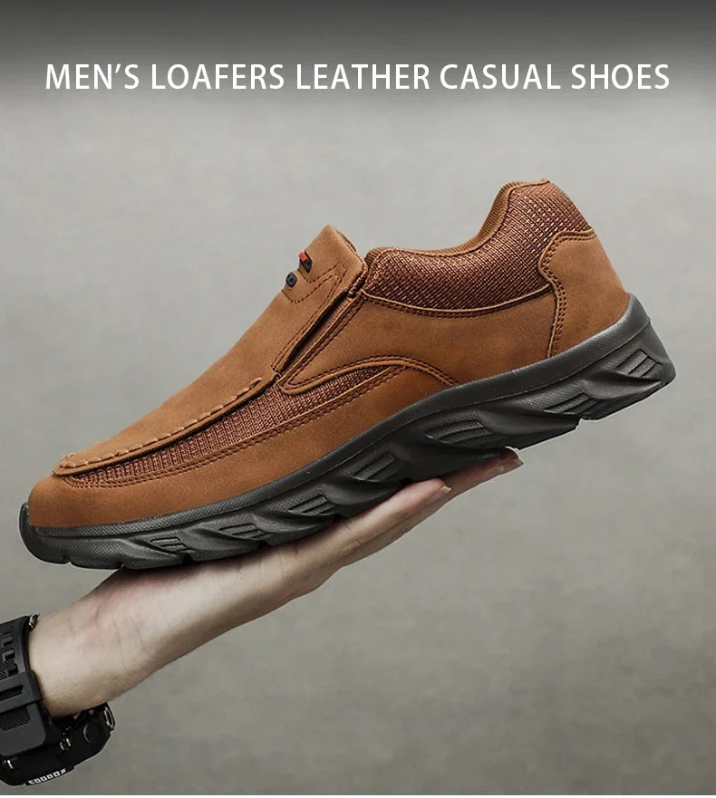 Brown men's leather casual loafer displayed in hand against a neutral background
