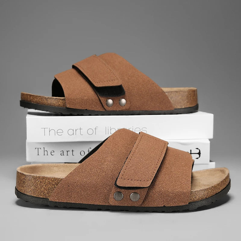 Brown suede men’s sandals with dual straps shown side by side on books