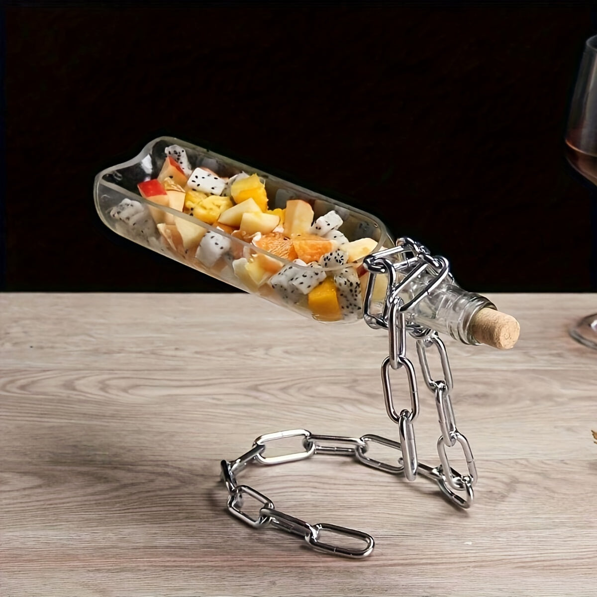 Chrome chain holder with bottle displayed vertically, soft lighting