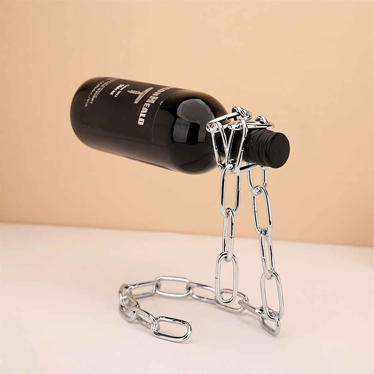 Chrome wine holder balancing clear bottle filled with fruit pieces