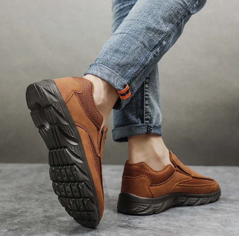 Close-up of black rubber sole on brown leather casual shoes with jeans, walking pose