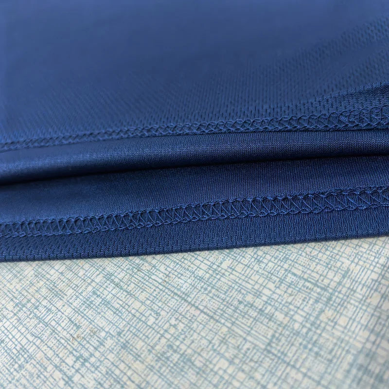 Close-up of double-stitched hem on navy blue mesh workout tank top
