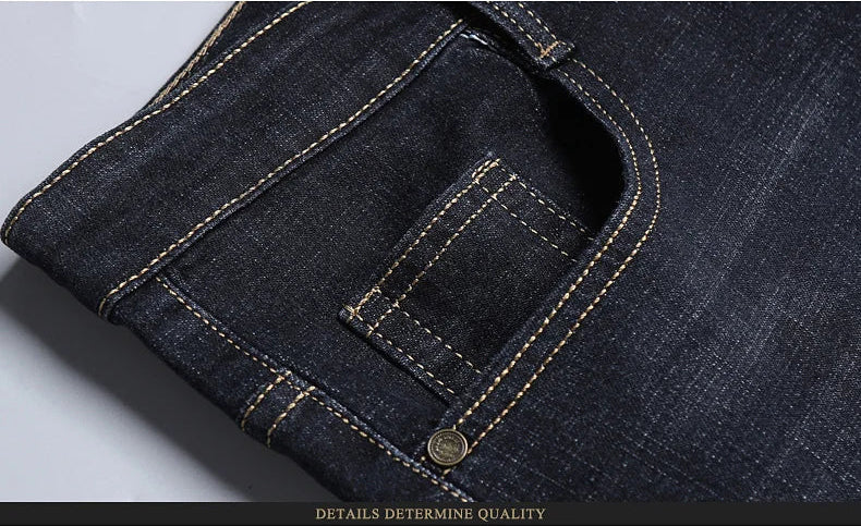 Close-up of front pocket detail with reinforced stitching on dark stretch jeans