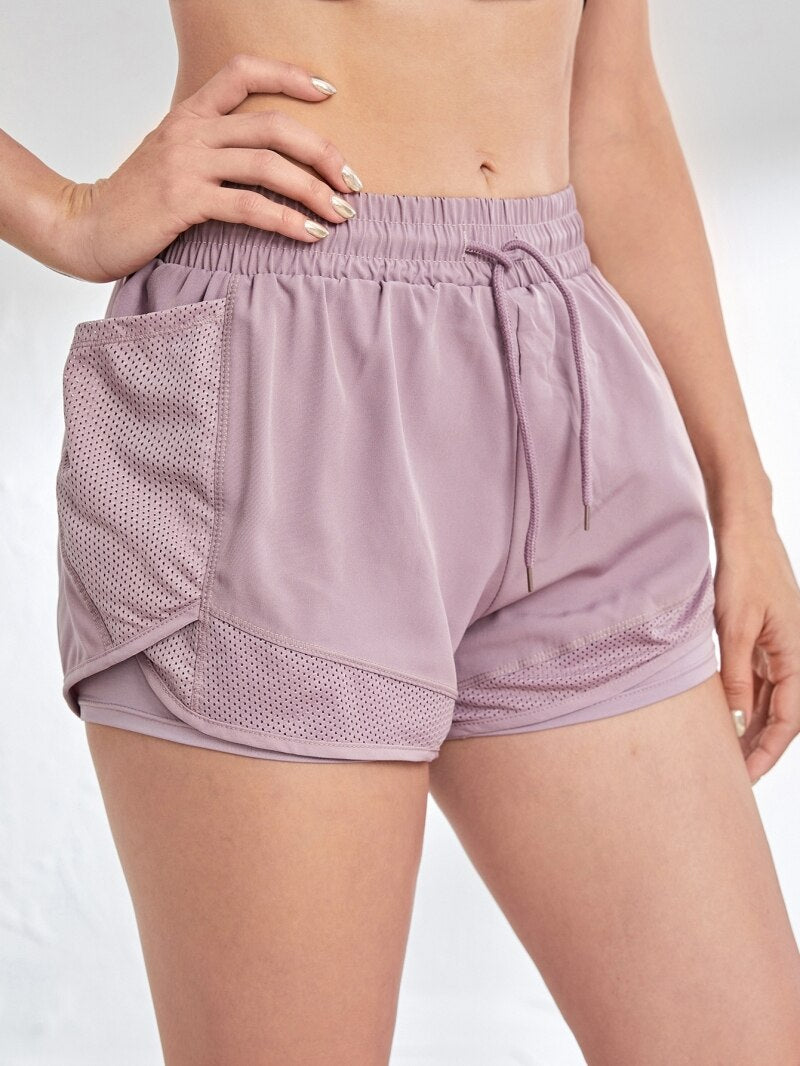 Close-up of lavender mesh workout shorts with elastic waistband and breathable outer layer