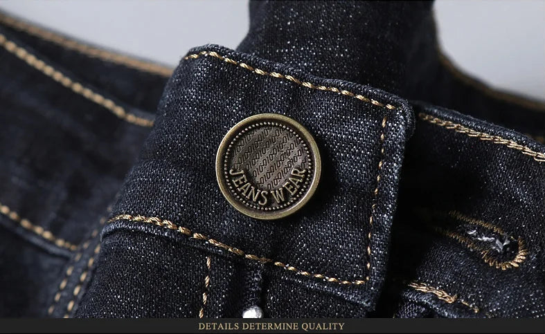 Close-up of metal jeans button on dark stretch denim with visible stitching