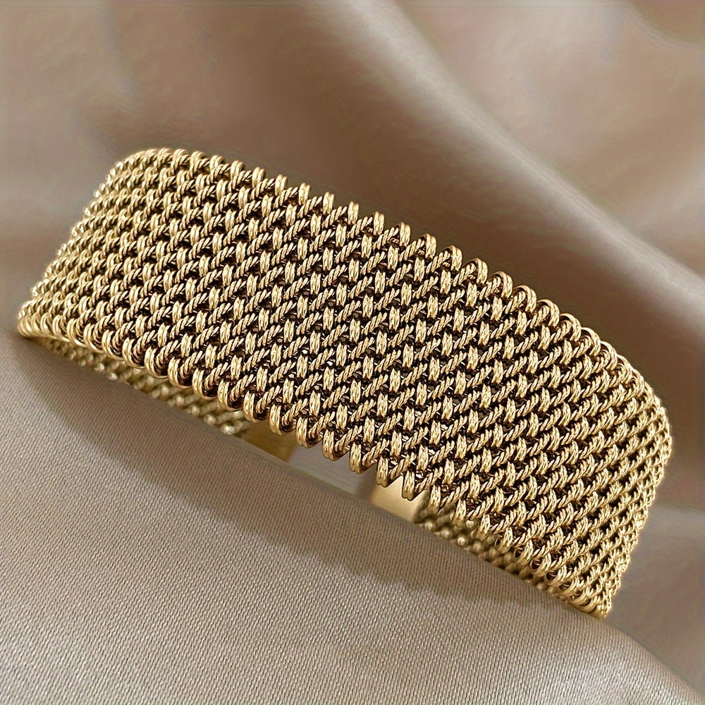 Close-up of wide mesh bracelet laid flat on satin background