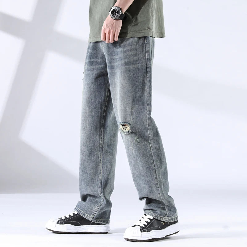 Close side-front view of storm grey blue distressed jeans with fading detail