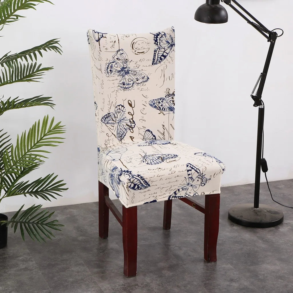 Cream stretch chair cover with blue butterfly and script pattern in a minimalist room
