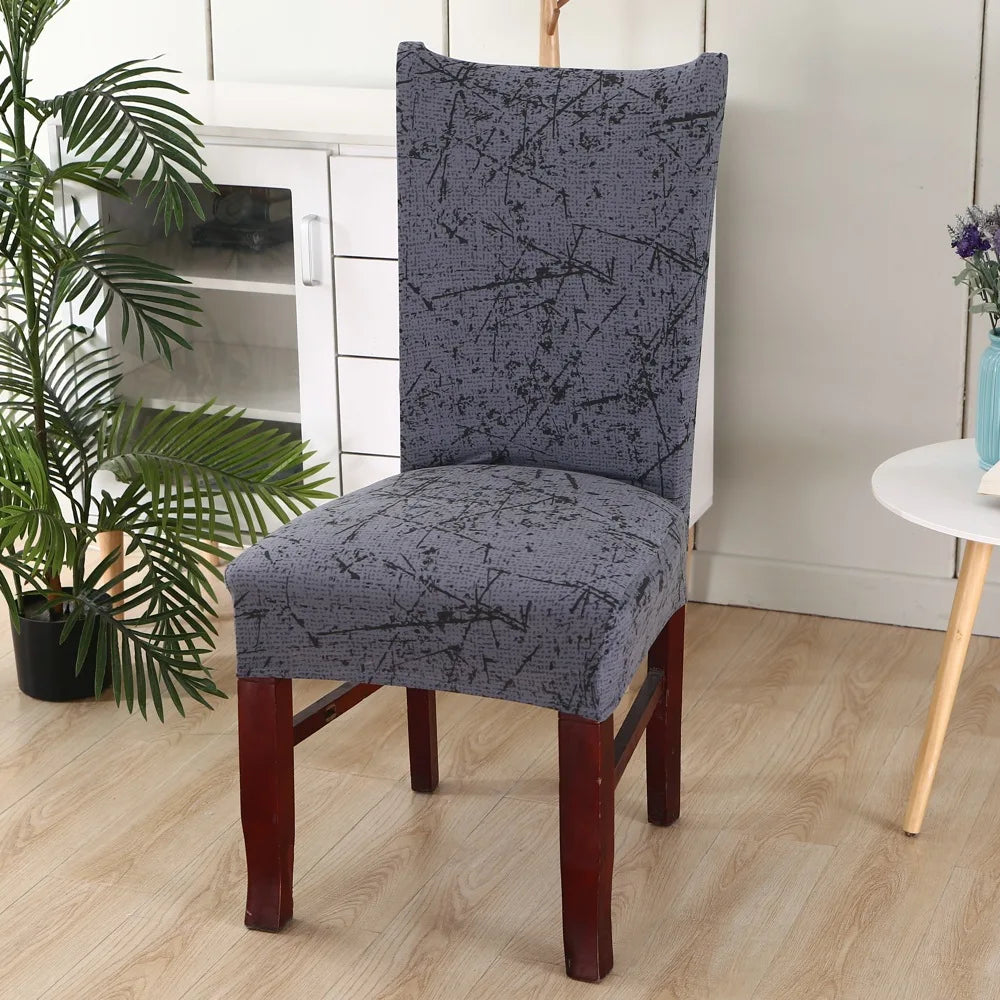 Dark gray textured chair cover with black paint-splatter design and wooden flooring