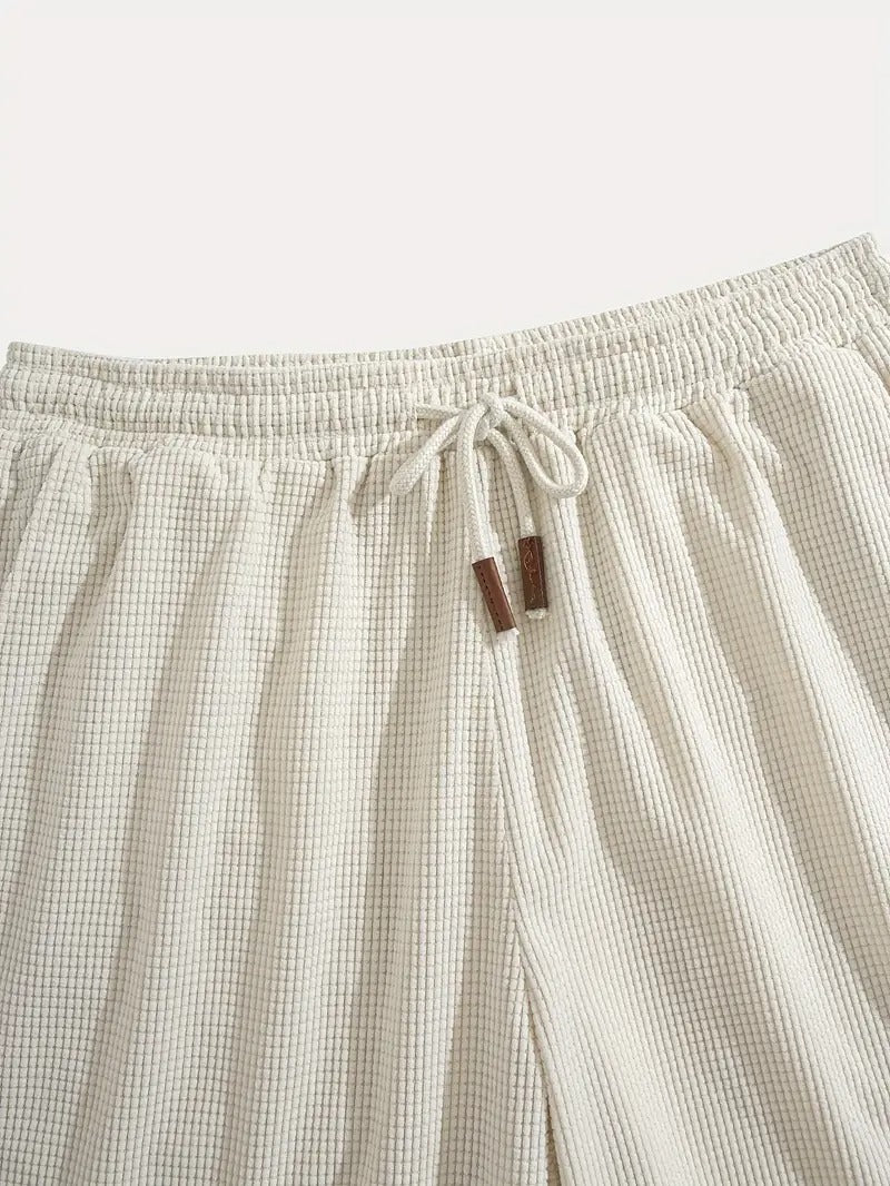Flat lay of cream textured drawstring casual shorts, close-up of label tag
