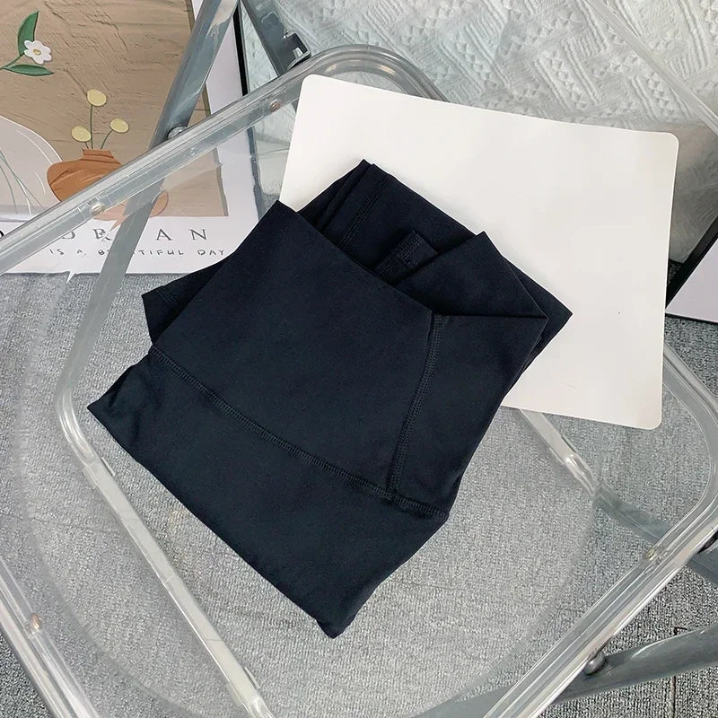 Folded black yoga leggings on chair