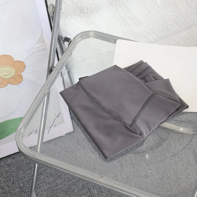 Folded dark gray yoga leggings on chair