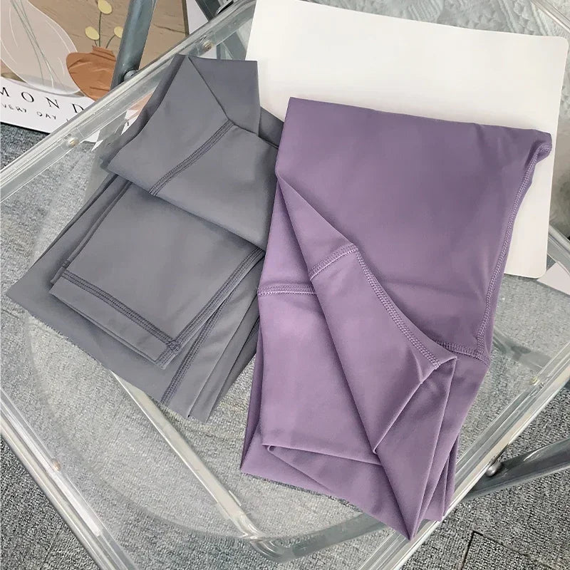 Folded gray and purple yoga leggings on chair