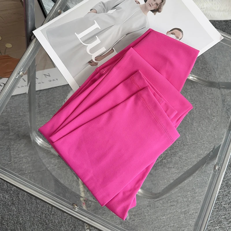 Folded hot pink yoga leggings on chair