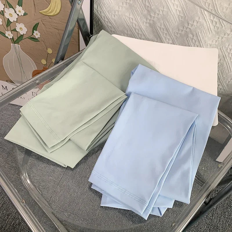Folded mint green and baby blue yoga leggings on chair