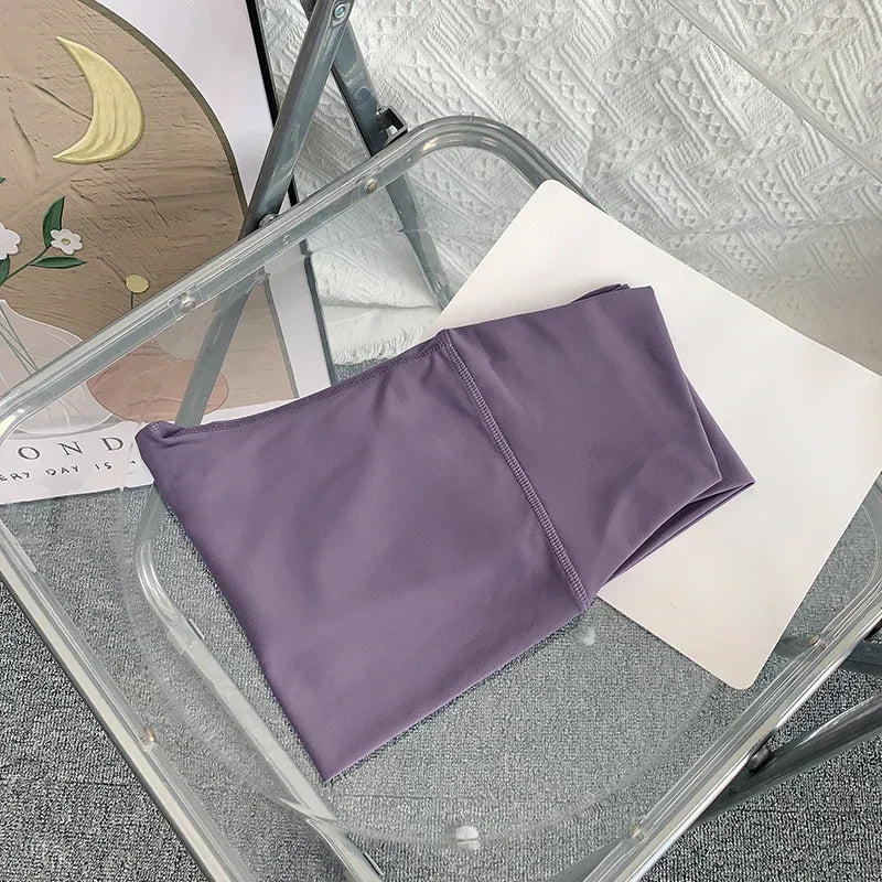 Folded purple yoga leggings on chair