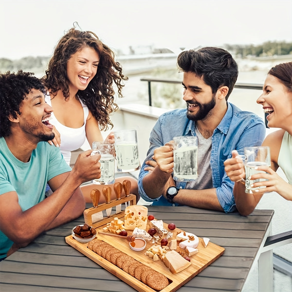 Friends enjoying drinks with wooden charcuterie board centerpiece at outdoor table