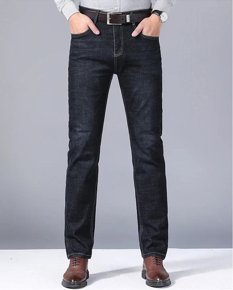Front full-body view of model wearing slim-fit dark wash jeans with brown shoes