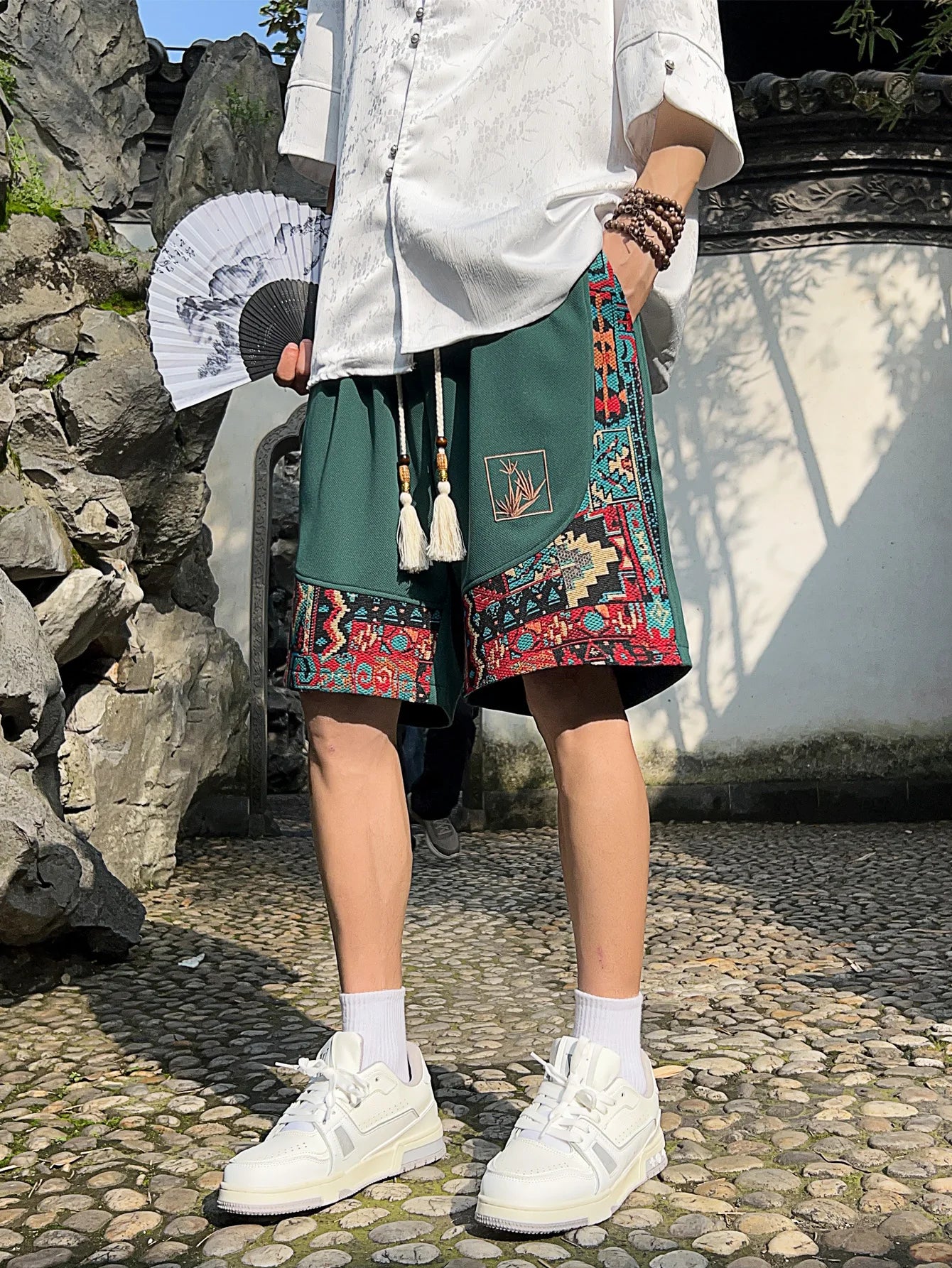 Front view of green ethnic drawstring shorts with pockets and embroidery