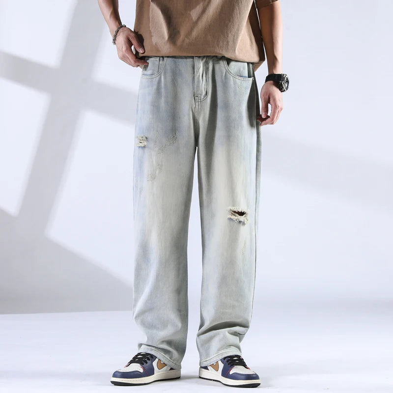 Frost-faded denim jeans with rips, front view under soft lighting