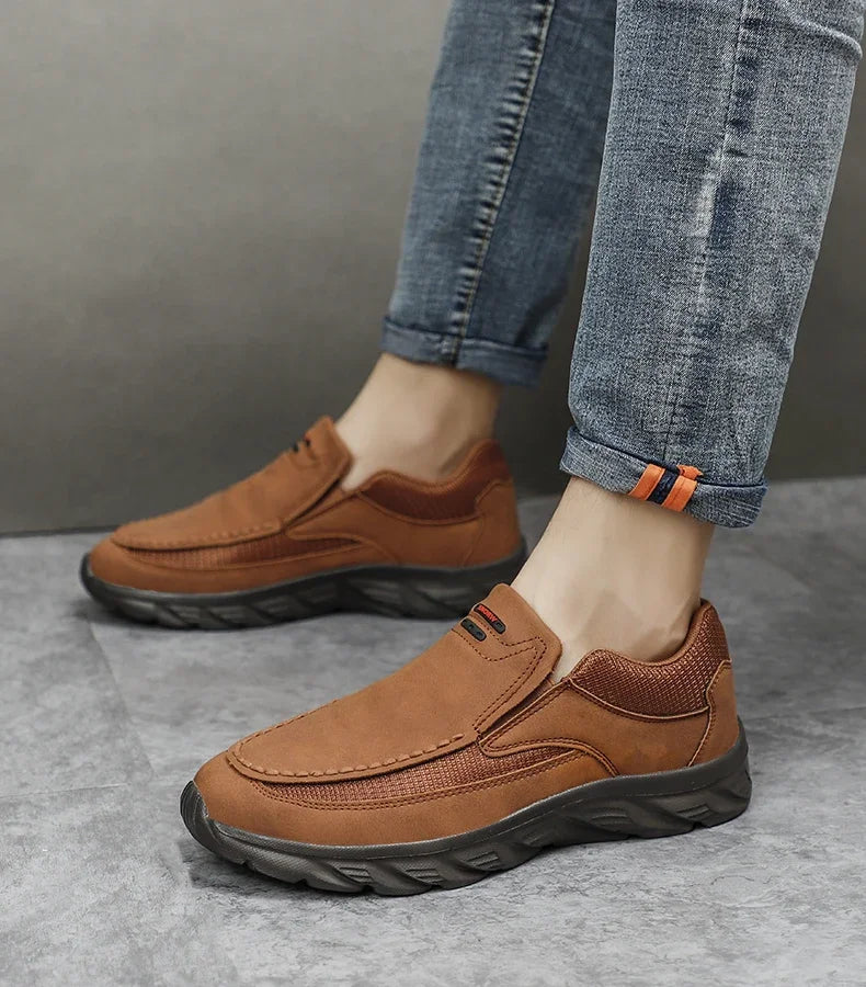 Full-body side view of man wearing brown leather casual shoes on tiled floor