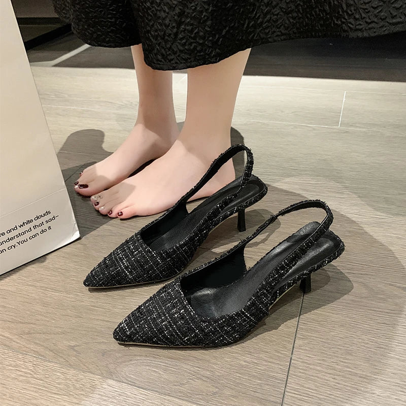 Group of tweed slingback heels on floor — black, blue, beige, and green colors