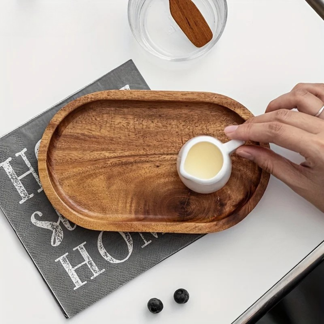Hand placing white mini jug on natural Mokura tray with visible grain on modern napkin
