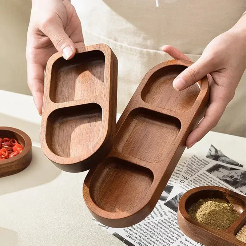 Hands holding two empty wooden sauce trays with 2 and 3 compartments respectively