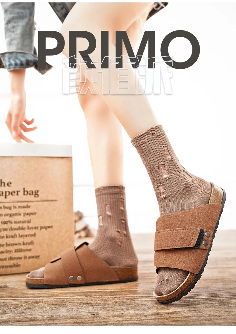 Male model stepping forward wearing taupe suede sandals with light beige socks indoors