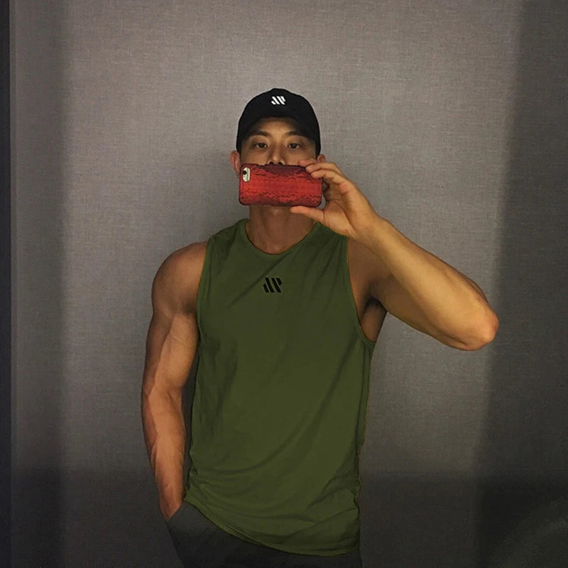 Man in army green quick-dry mesh tank top for workouts, athletic front pose in mirror