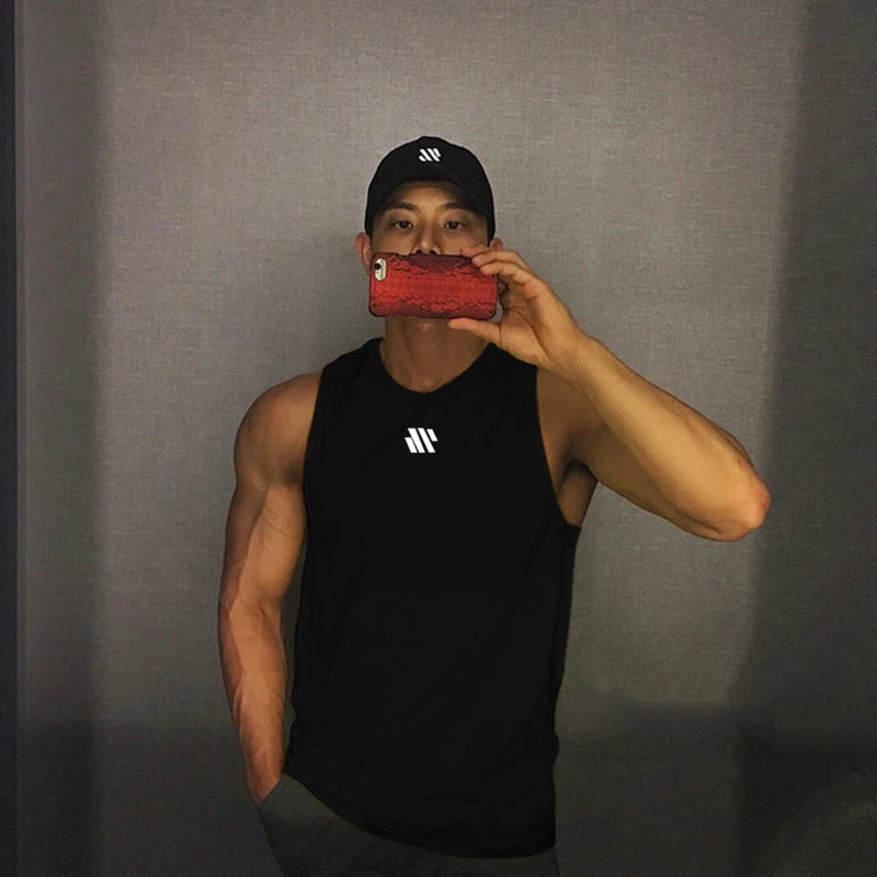 Man in black quick-dry mesh tank top for workouts, athletic front pose in mirror