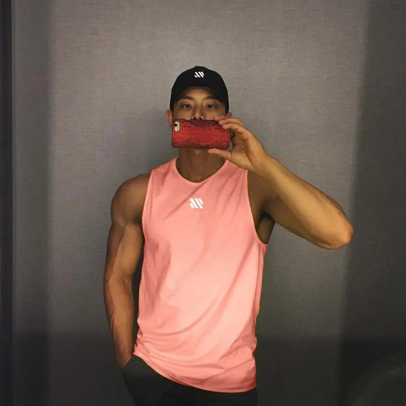 Man in pink quick-dry mesh tank top for workouts, athletic front pose in mirror