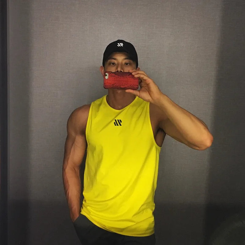 Man in yellow quick-dry mesh tank top for workouts, athletic front pose in mirror