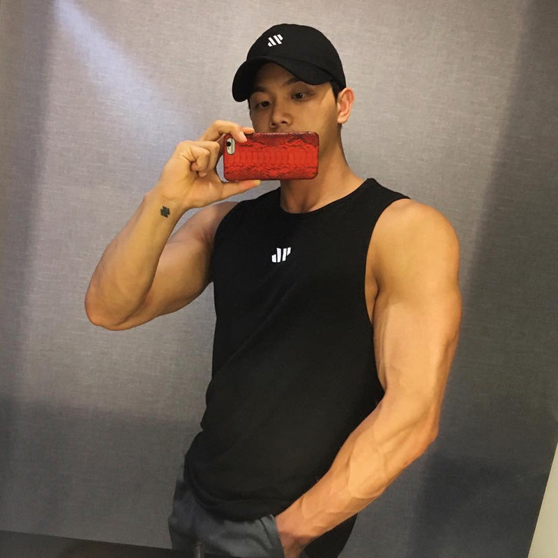 Man wearing black mesh training tank top with reflective logo, mirror selfie view