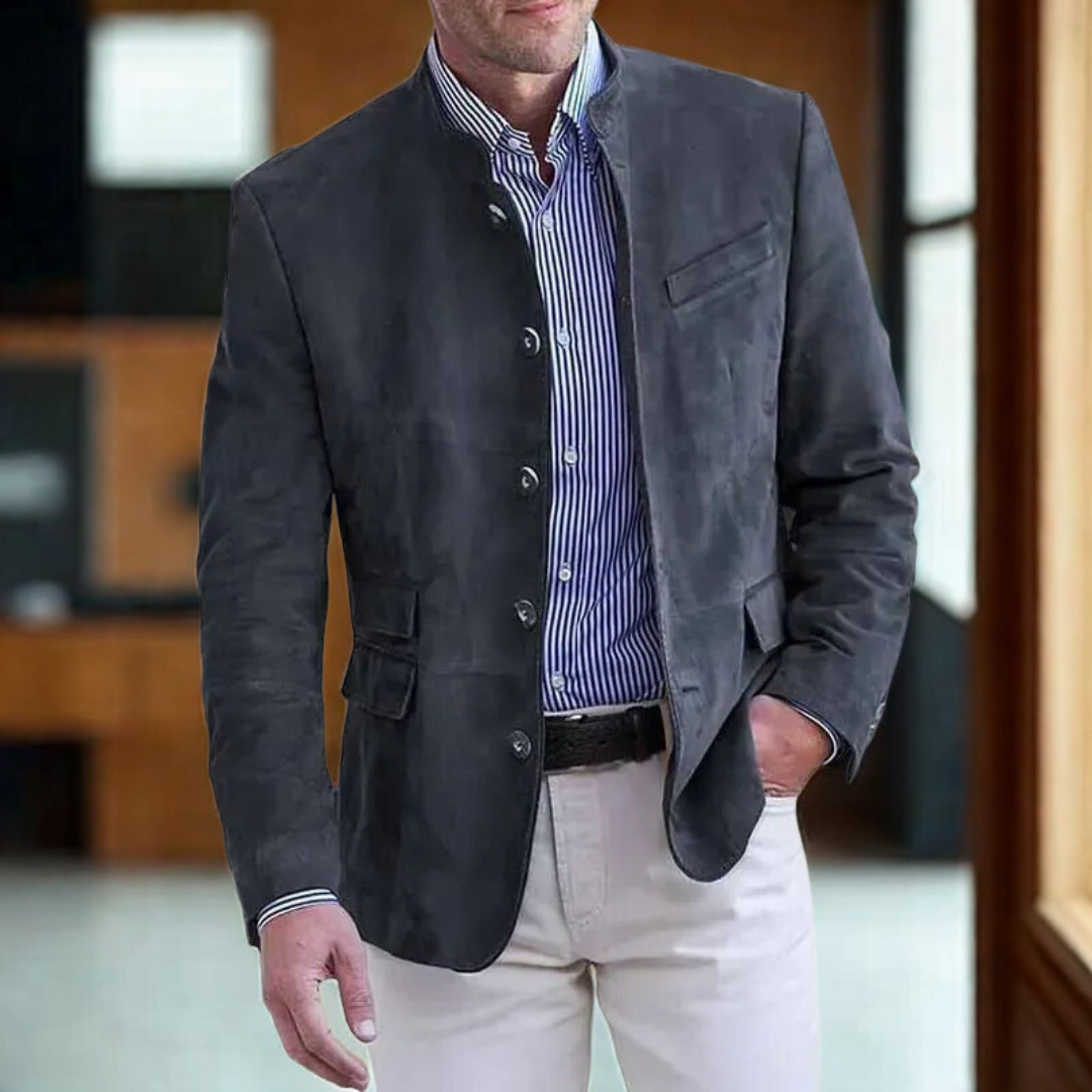 Men's charcoal suede-look blazer with stand collar, styled indoors with modern office background