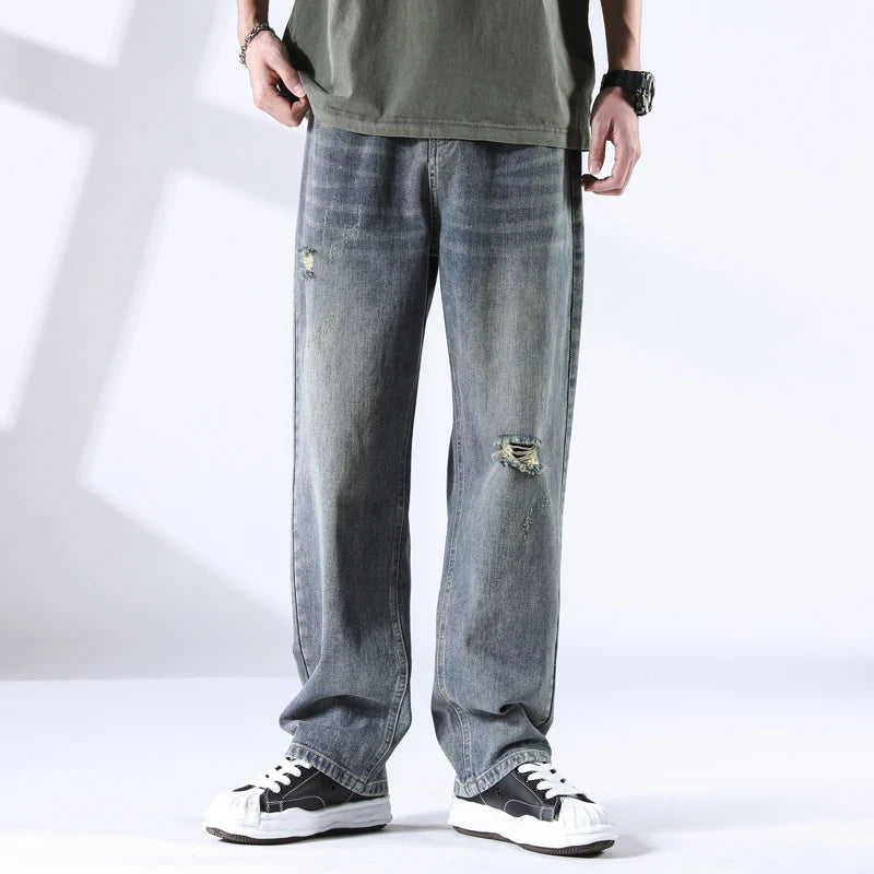 Men wearing stone blue straight leg jeans with ripped knee, light fade wash, front view
