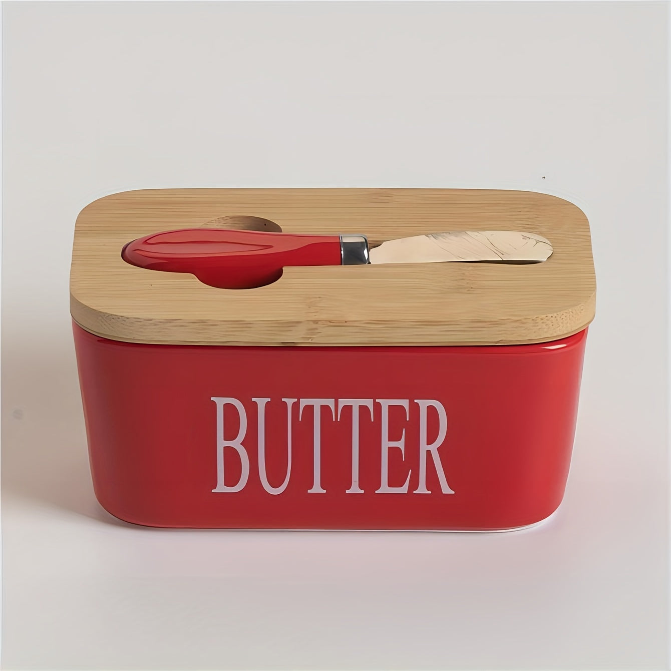 Red ceramic butter dish with bamboo lid and spreader slot, angled view