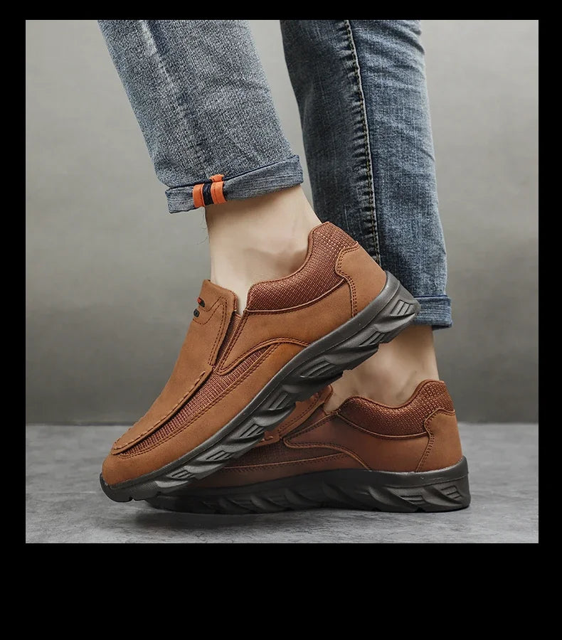 Side profile of brown leather loafer-sneakers paired with rolled-up denim jeans