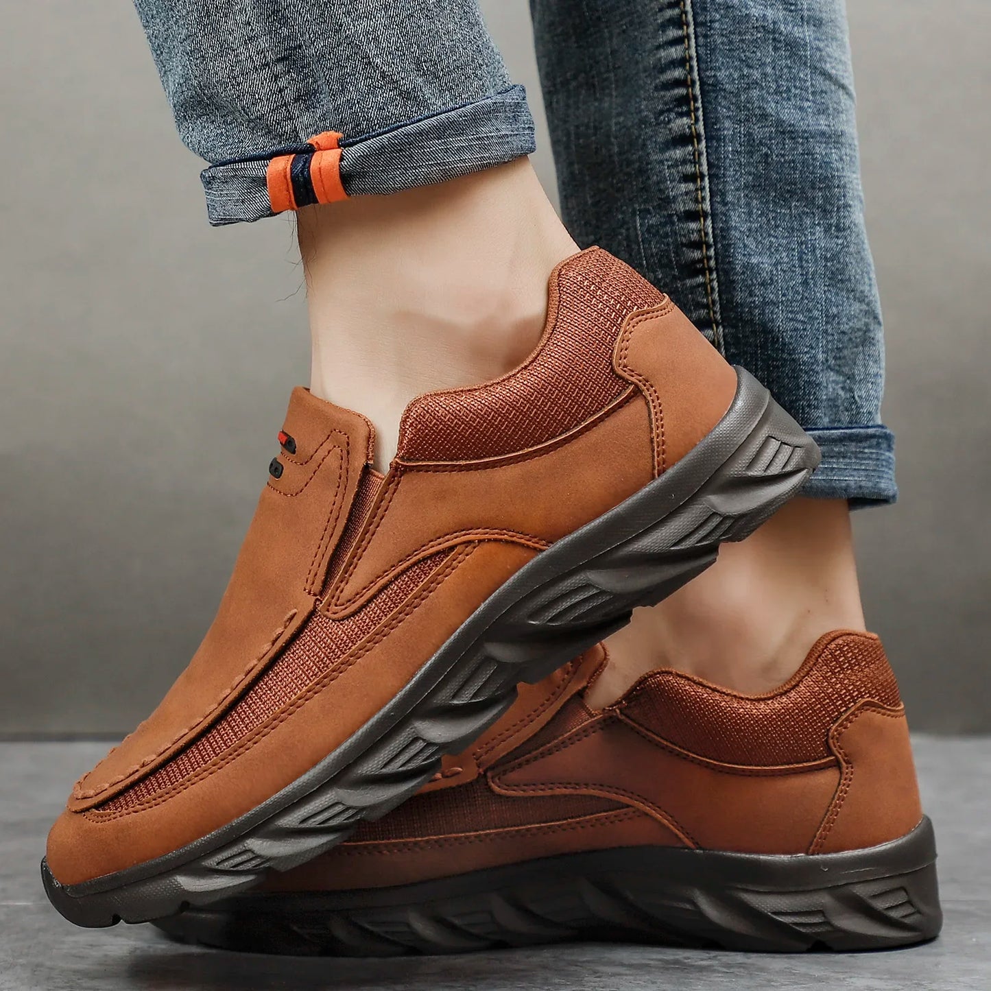 Side view of Arlen Flex brown leather loafers being worn with je