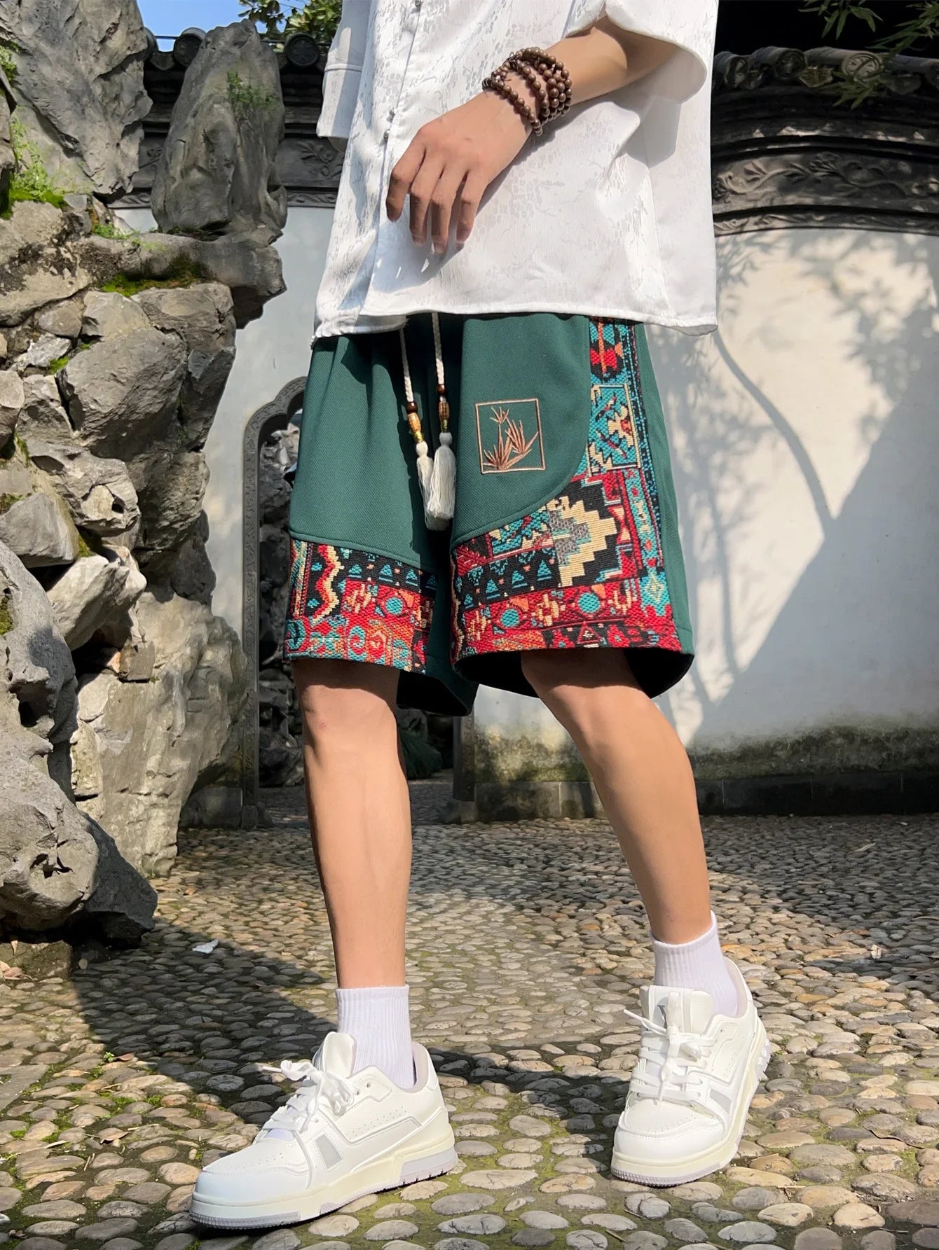 Side view of green woven shorts showing back pocket and relaxed fit