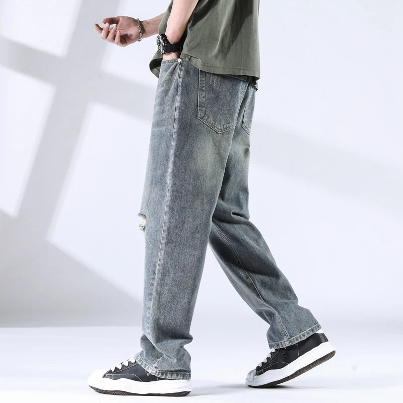 Side view of ripped washed jeans in stone blue, relaxed fit